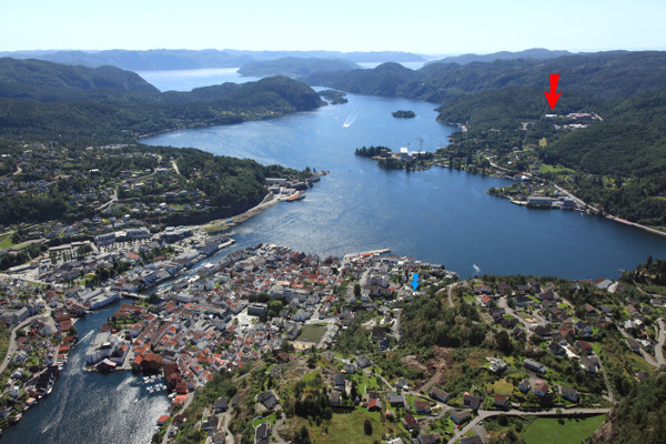 Overview of Flekkefjord with our factory shown with a red arrow as well as our previous location (blue arrow)